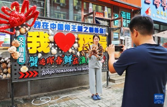 9月21日，游客在吉林省琿春市一處帝王蟹元素主題裝飾前拍照留念。新華社發(fā)