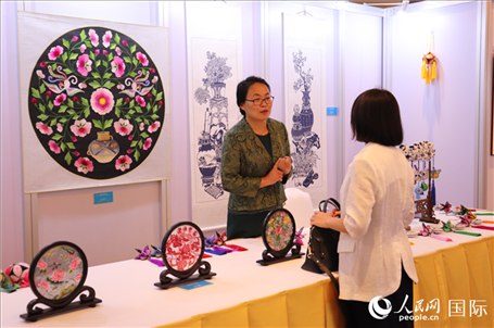 青海非遺文化傳承人向嘉賓介紹展品。人民網實習生姚欣可攝