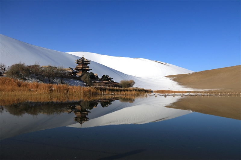 鳴沙山月牙泉景區(qū)雪景。敦煌市委宣傳部供圖，張曉亮攝