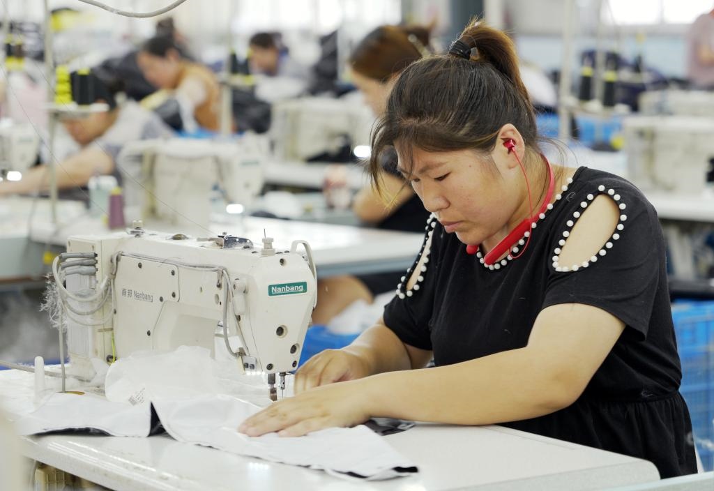 5月20日，村民在李寨村服裝加工廠內(nèi)忙碌。河南省周口市沈丘縣馮營鎮(zhèn)李寨村地處豫東平原。近年來，乘著脫貧攻堅(jiān)與鄉(xiāng)村振興政策的東風(fēng)，李寨村積極探索產(chǎn)業(yè)發(fā)展模式，通過“龍頭企業(yè)+村集體經(jīng)濟(jì)+農(nóng)戶”的方式，逐漸發(fā)展形成肉牛養(yǎng)殖、設(shè)施農(nóng)業(yè)、服裝加工、康養(yǎng)民宿等產(chǎn)業(yè)，以產(chǎn)業(yè)振興助力鄉(xiāng)村振興。新華社記者 李嘉南 攝