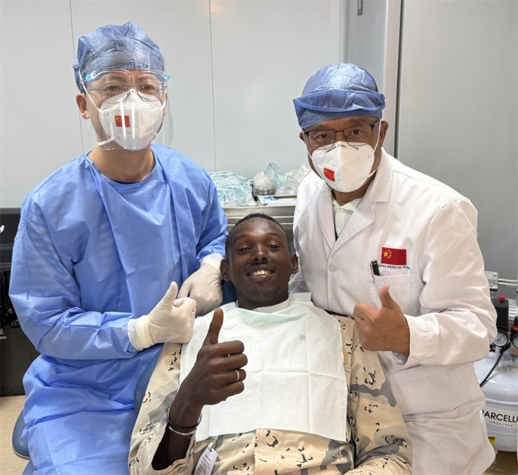 援吉醫(yī)療隊口腔科王瑋主任與“和平方舟”號醫(yī)院船醫(yī)務(wù)人員共同為一名當(dāng)?shù)匮浪柩谆颊咴\療。中國（山西）第23批援吉布提醫(yī)療隊供圖