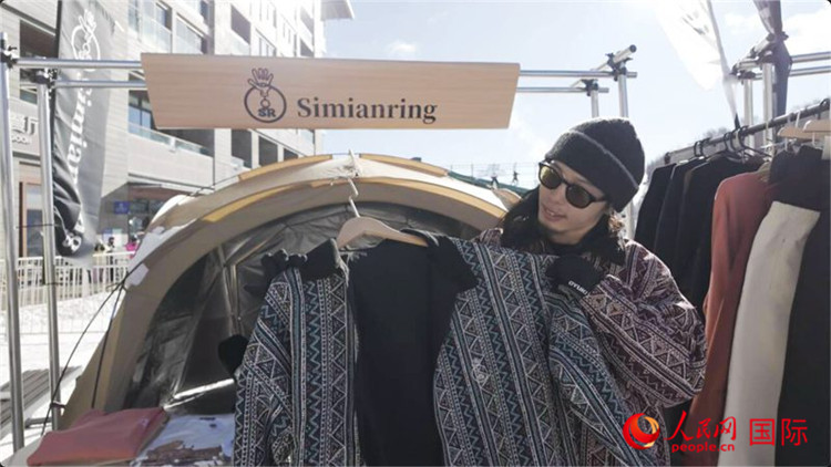 藤田周正在展示自己設(shè)計的滑雪服。人民網(wǎng)記者 袁蒙攝