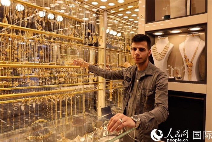 一名銷售員展示黃金飾品。人民網(wǎng) 伊納斯·易卜拉欣攝