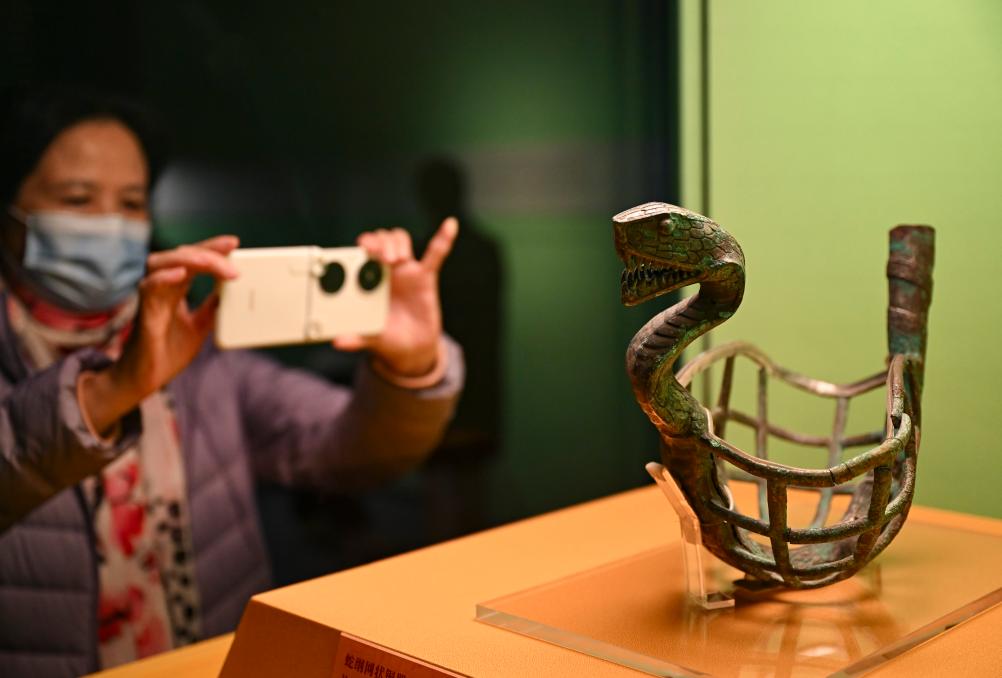1月14日，觀眾在上海博物館蛇年迎春展拍攝展品蛇綱網(wǎng)狀銅器。新華社發(fā)（陳浩明攝）