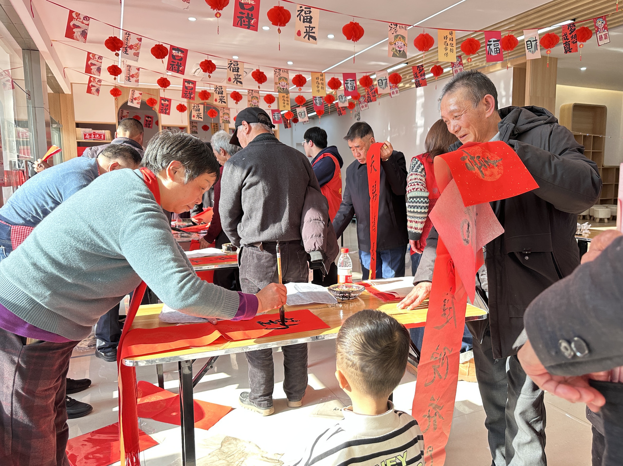 今年春節(jié)前夕，慶元縣濛洲街道同濟(jì)新村，一場(chǎng)送春聯(lián)活動(dòng)熱鬧舉行。慶元縣融媒體中心 供圖