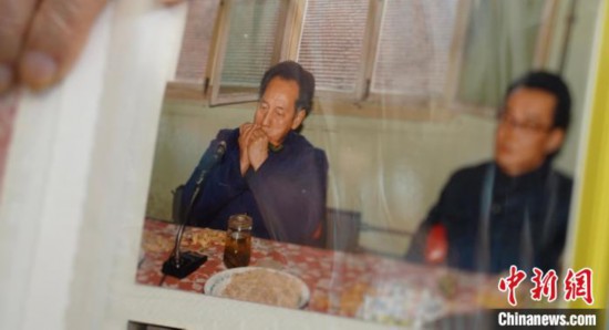 2月7日，劉潤林展示1986年黃旭華(左)在同樂會上吹口琴的老照片。中新社記者 鄒浩 攝