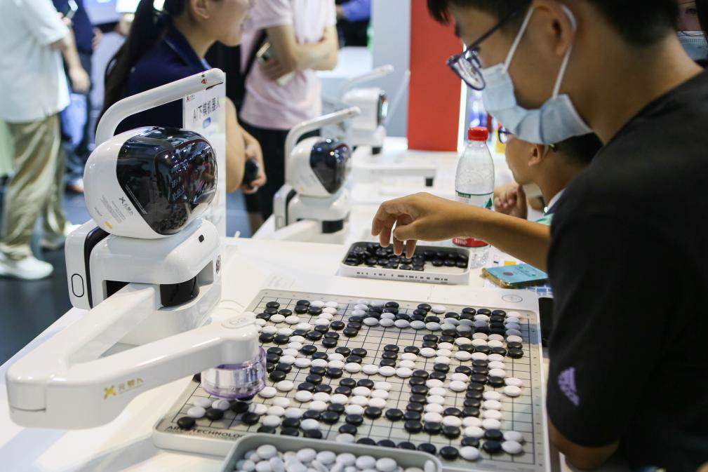 2023年7月7日，元蘿卜AI下棋機(jī)器人與觀眾對弈。2023年7月6日至8日，2023世界人工智能大會在上海舉行。新華社記者 辛夢晨 攝