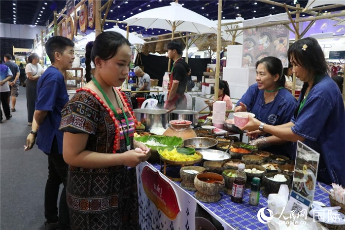 游客在攤位前購買特色美食。朱瀟逸攝