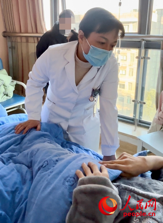 鄧茜查房時(shí)詢問(wèn)患者情況。人民網(wǎng)記者 金慧慧攝