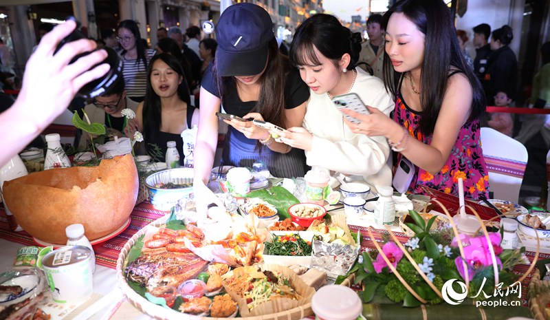 游客拍照打卡體驗(yàn)長(zhǎng)桌宴。人民網(wǎng)記者 符武平攝