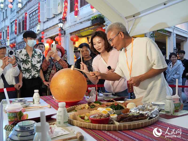 嘉賓品嘗海南傳統(tǒng)美食“煎堆”。人民網(wǎng)記者 張力洋攝