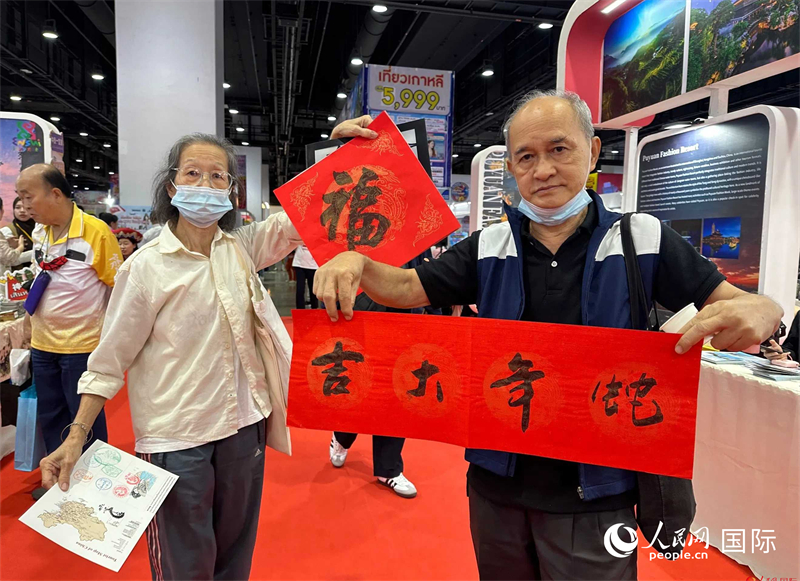 2025蛇年春節(jié)，泰國市民展示他們領到的華人手寫春聯(lián)。人民網記者 簡承淵攝