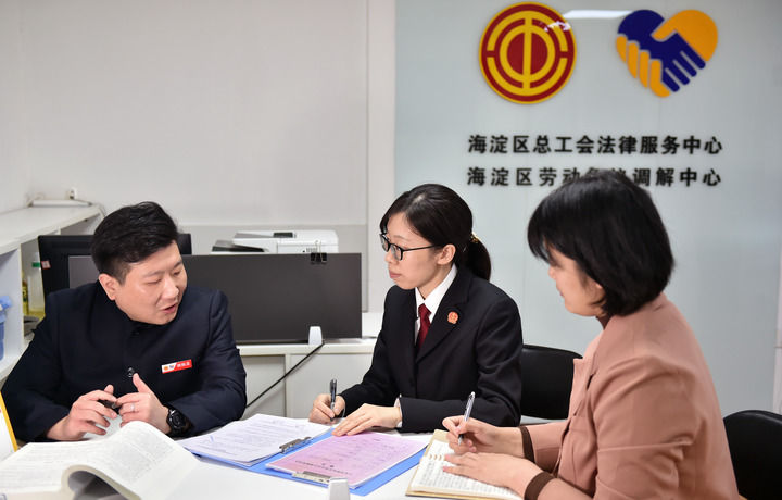 2025年3月6日，在北京市海淀區(qū)總工會勞動爭議調(diào)解中心，海淀區(qū)人民法院法官王琰（中）與該中心工作人員就糾紛化解情況進行溝通。新華社記者 趙婷婷 攝