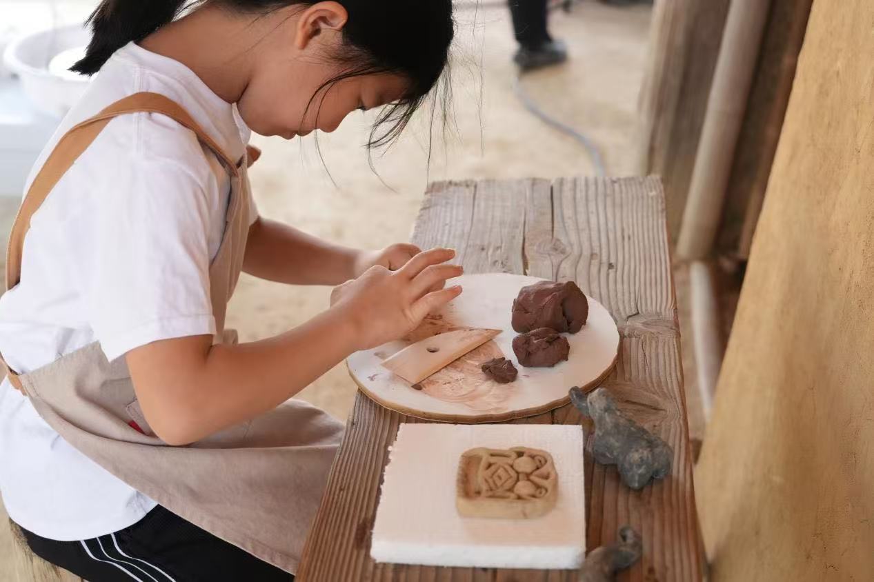 游客制作良渚特色陶藝品。良渚博物院供圖