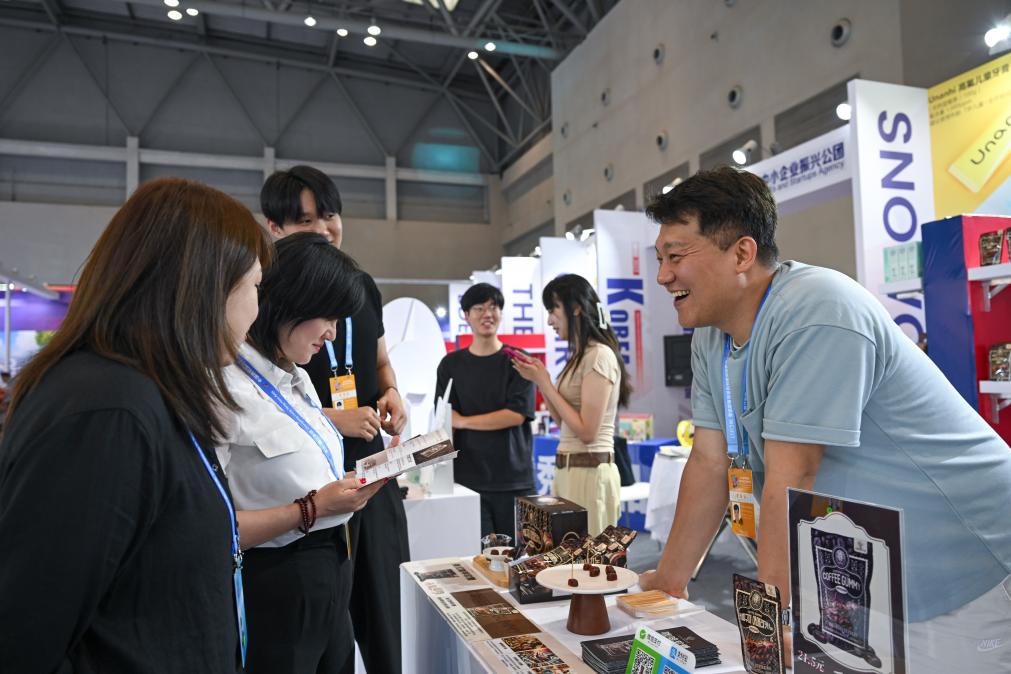 5月22日，韓國展商（右一）在西洽會現(xiàn)場向參觀者介紹產(chǎn)品。新華社記者 陳誠 攝