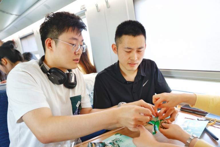 G232次旅客親手制作端午荷包和五彩繩。王磊攝