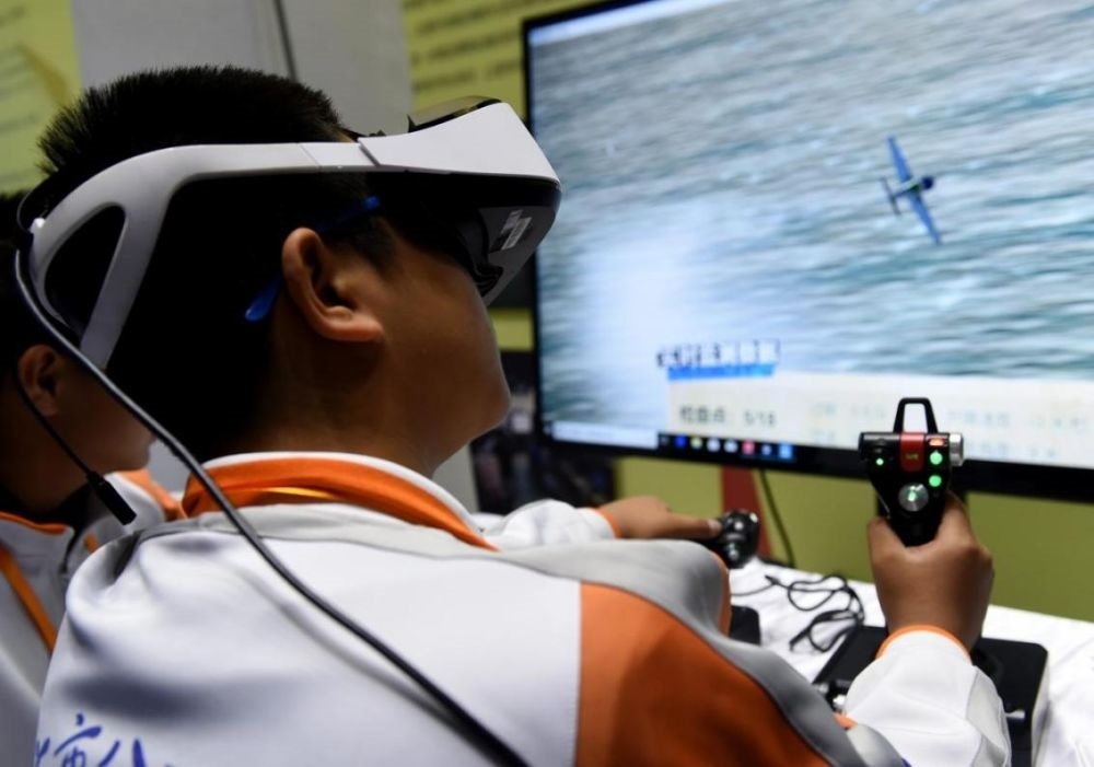 北京市八一學(xué)校的學(xué)生在北京市中小學(xué)生特色科技活動(dòng)展示上體驗(yàn)VR技術(shù)（2018年11月24日攝）新華社記者 羅曉光 攝。