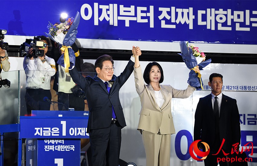 6月4日凌晨，確定當(dāng)選韓國(guó)總統(tǒng)的李在明舉手向歡呼的支持者們致意。 人民網(wǎng) 康炯彬攝